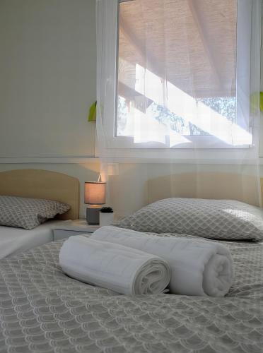 a bedroom with two twin beds and a window at Mobile Home Olive Tree in Pakoštane