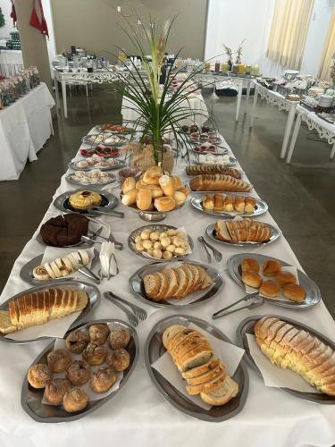 a long table filled with different types of pastries at VITORIA GARDEN in Águas de Lindóia