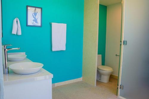 a blue bathroom with a sink and a toilet at Baja Luxury With Spectacular Ocean Views Ensenada in Marisol