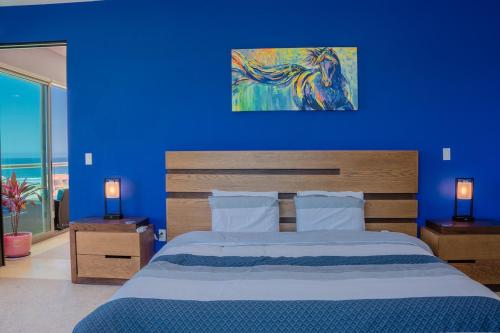 a blue bedroom with a bed and a blue wall at Baja Luxury With Spectacular Ocean Views Ensenada in Marisol
