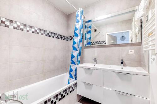 a bathroom with a white sink and a bath tub at Perollier - CI - Lyon 2 - Bedroom apartment with balcony and pool in Écully