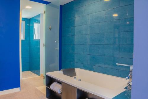 a bathroom with a tub and a blue wall at Baja Luxury With Spectacular Ocean Views Ensenada in Marisol