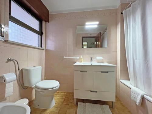 een badkamer met een toilet, een wastafel en een spiegel bij Alamar T1 Altura Beach in Altura