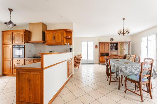 une cuisine et une salle à manger avec une table et des chaises dans l'établissement Maison Lumineuse Près La Rémigeasse, à Dolus-d'Oléron