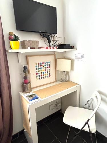 un bureau avec un moniteur et une chaise dans l'établissement Le studio Grenelle, à Paris