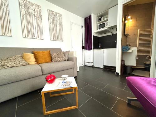 un salon avec un canapé et une table dans l'établissement Le studio Grenelle, à Paris