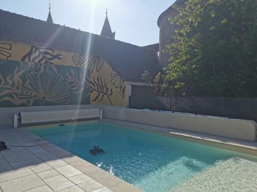 a swimming pool in front of a wall at Villa spacieuse près de Senonches avec piscine privée in Tardais