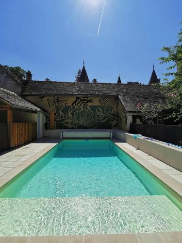 a swimming pool with blue water in front of a building at Villa spacieuse près de Senonches avec piscine privée in Tardais