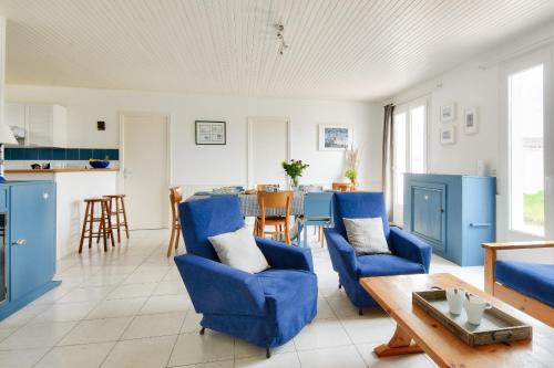 un salon avec des chaises bleues et une table dans l'établissement Maison pour 10 avec jardin à Noirmoutier, à Noirmoutier-en-l'lle