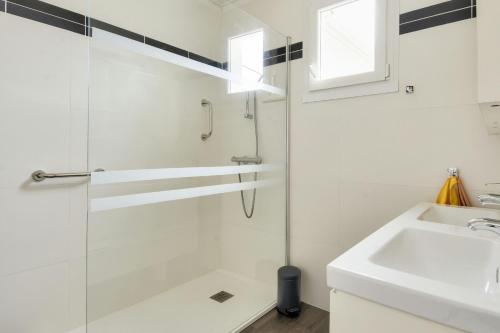 a white bathroom with a shower and a sink at Maison pour 10 avec jardin à Noirmoutier in Noirmoutier-en-l'lle