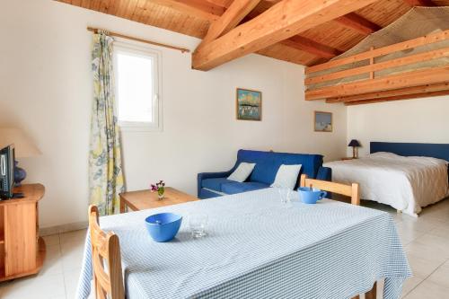 a dining room with a table and a bed at Maison pour 10 avec jardin à Noirmoutier in Noirmoutier-en-l'lle