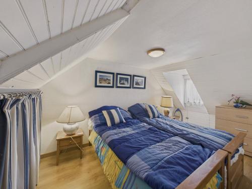 une chambre avec un lit avec une couette bleue dans l'établissement Maison pour 8 avec grand jardin à 150m de la mer, à Trévou-Tréguignec