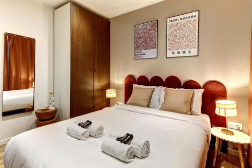 une chambre avec un grand lit avec des serviettes dessus dans l'établissement Charme Parisien pres des Buttes-Chaumont, à Paris