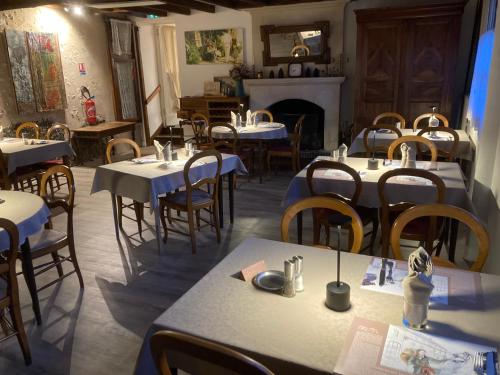 une salle à manger avec tables et chaises et une cheminée dans l'établissement Logis Le Petit Trôo du Cheval Blanc, à Trôo