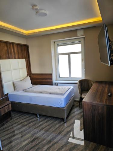 a bedroom with a bed and a window and a tv at Hotel City Faber in Worms