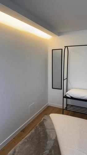 a white room with a bed and a mirror at Rua Nova in Sarria