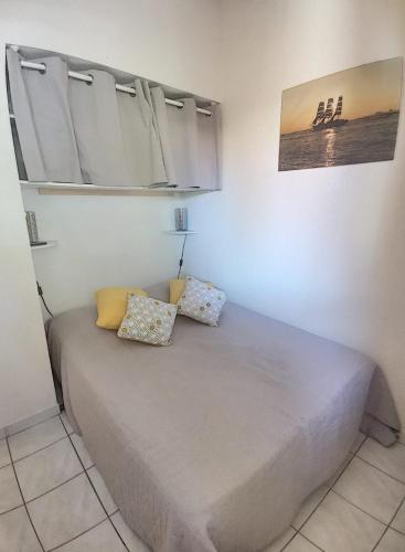 un lit dans une chambre avec deux oreillers dessus dans l'établissement Bois de Jade N100, à Argelès-sur-Mer