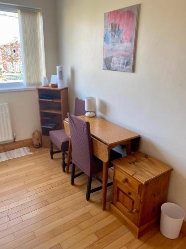 a room with a desk and a table and chairs at The Mansion Room in Manchester
