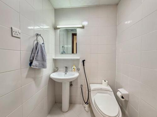 a white bathroom with a toilet and a sink at Welcome to cozy one bedroom in Abu Dhabi