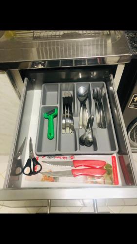 a drawer in a refrigerator filled with utensils at Welcome to cozy one bedroom in Abu Dhabi