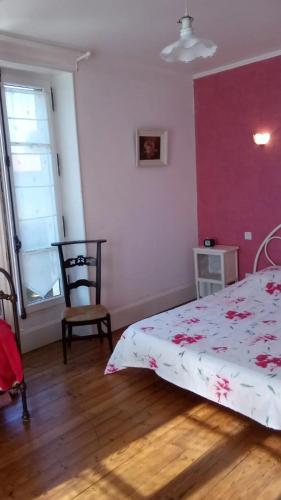 une chambre avec un lit et une chaise dans l'établissement Maison spacieuse à Vic-Fezensac avec jardin, à Vic-Fezensac