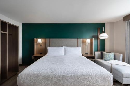 a bedroom with a large bed and a green wall at Holiday Inn St-Jean-sur-Richelieu Congrès by IHG in Saint-Jean-sur-Richelieu
