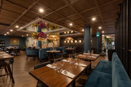 a restaurant with wooden tables and blue chairs at Holiday Inn St-Jean-sur-Richelieu Congrès by IHG in Saint-Jean-sur-Richelieu
