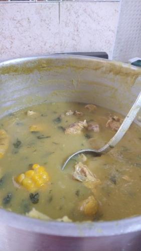 a pot of chicken soup with a spoon in it at Quinta Divina Providencia in Fusagasuga