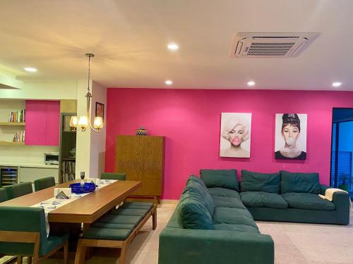 a living room with a green couch and a pink wall at Baja Luxury With Spectacular Ocean Views Ensenada in Marisol