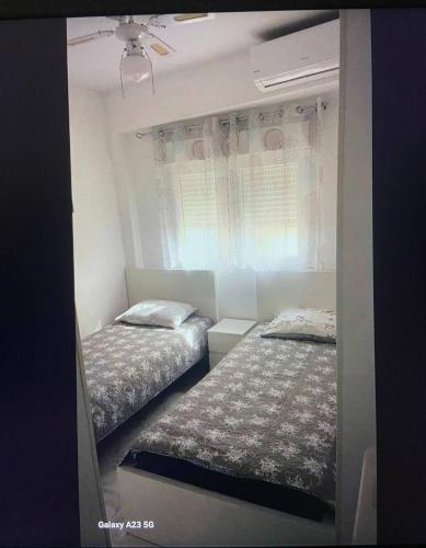 a bedroom with two beds and a window at Apartamento Alicia in Daimuz