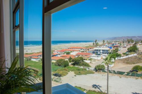 a view of the beach from a window at Baja Luxury With Spectacular Ocean Views Ensenada in Marisol