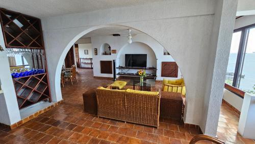 uma sala de estar com um arco em uma casa em Condumel em Cozumel