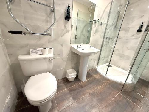 a bathroom with a toilet and a shower and a sink at The Clubhouse Nairn in Nairn