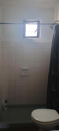 a bathroom with a toilet and a window at Casa de la Nona in Cordoba