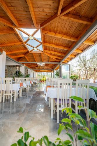 a dining room with white tables and white chairs at Aleksander ApartHotel in Ksamil