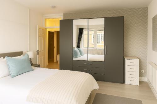 ロンドンにあるLuxury Flat by Tower Bridge, London - 2 Bedrooms, Free Parkingの大きなベッドと大きな鏡のある寝室