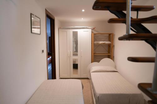 a room with two beds and a closet at Old town apartment with sea view private rooftop in Giovinazzo