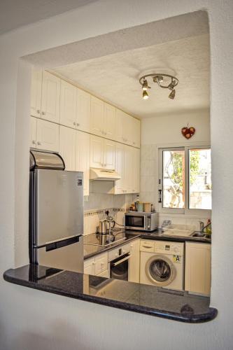 a kitchen with a refrigerator and a stove top oven at Villa Margo by the Sea in Paphos City