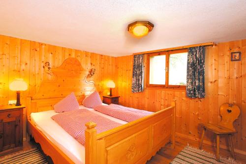 a bedroom with a bed in a wooden room at Almhütte Fellimännle in Silbertal