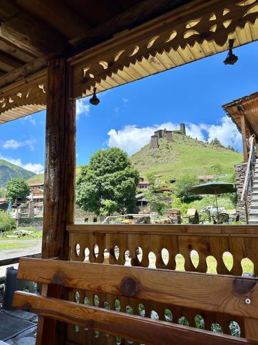 a bench with a view of a castle on a hill at Guesthouse Lasharai in Omalo