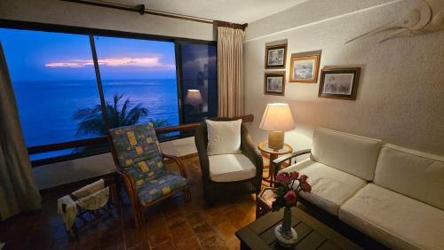 een woonkamer met een bank en een groot raam bij Condumel in Cozumel