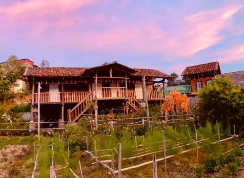 a house in the middle of a field at Lương Sơn Homestay in Bản Gùm