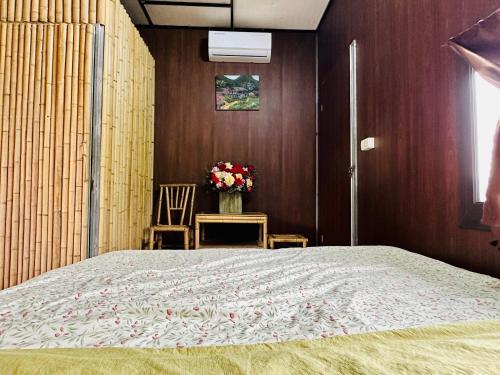 a bedroom with a large bed and a vase of flowers at Lương Sơn Homestay in Bản Gùm