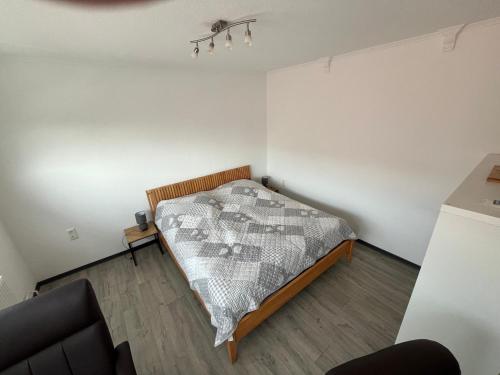 a bedroom with a bed and a chair in it at Ferienwohnung Käthe in Rhauderfehn