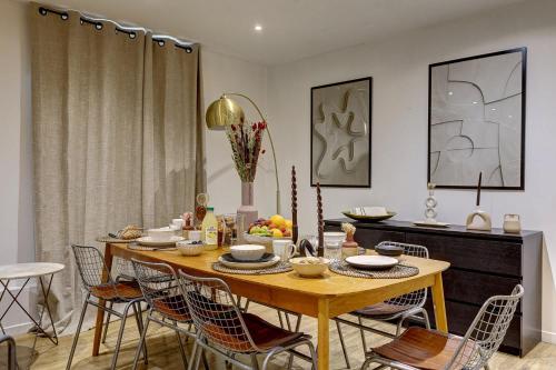 une salle à manger avec une table et des chaises en bois dans l'établissement Havre d'elegance pour 8 personnes au Coeur de Paris, à Paris