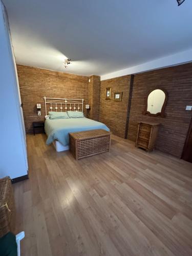 a bedroom with a large bed and a wooden floor at Alcalá zona centro duplex in Alcalá la Real