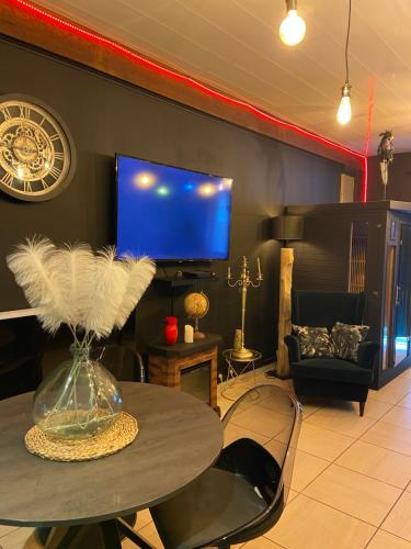 un salon avec une table et une télévision dans l'établissement Blackroom, à Arles