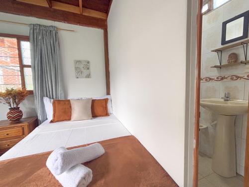 a bedroom with a bed with towels on it at Las Casas de Tomate in Guatapé