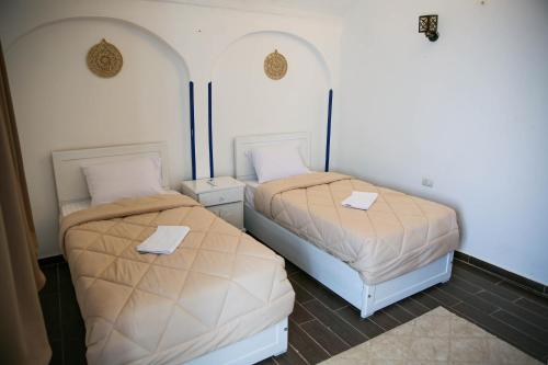two beds in a room with two tr beds at Sharqotel Luxor in Luxor