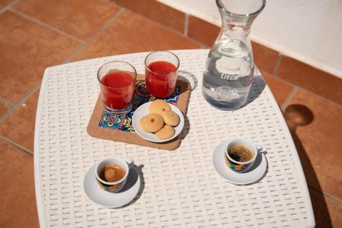 a table with two cups of tea and a tray of cookies at Old town apartment with sea view private rooftop in Giovinazzo